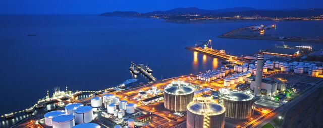 Industrieanlage am Meer bei Nacht